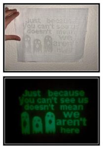 finished ghostly cross stitch with glow in the dark threads